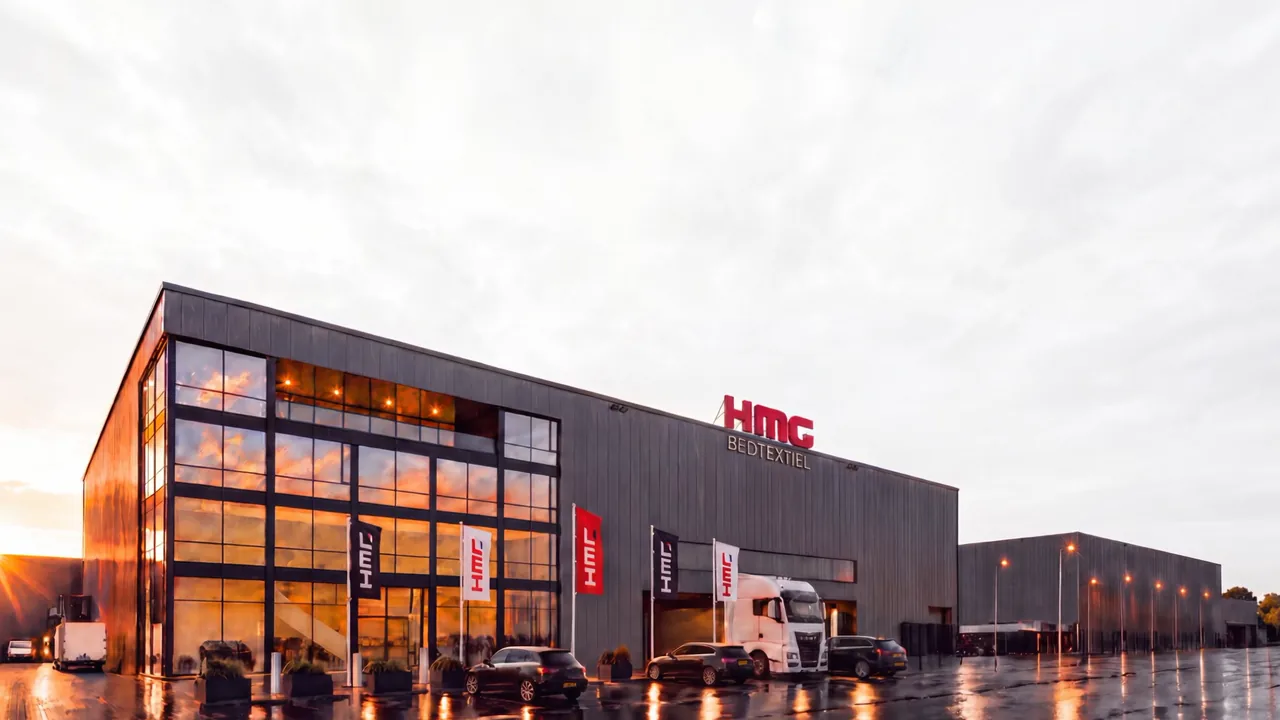 Die Glasfassade des Werks von HMG Bedtextiel in Eindhoven im Abendlicht
