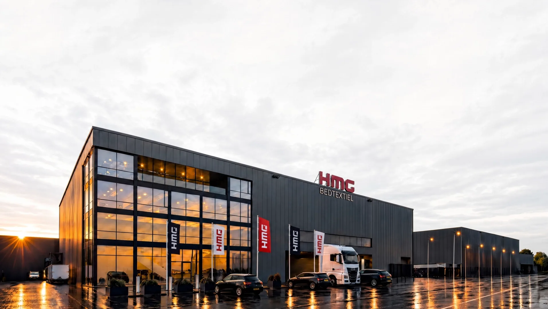 De productiefaciliteit van HMG Bedtextiel bij zonsondergang